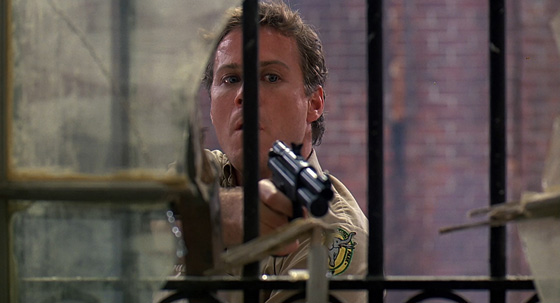 Oliver (John Heard) prepares to tranquilize a deadly panther.