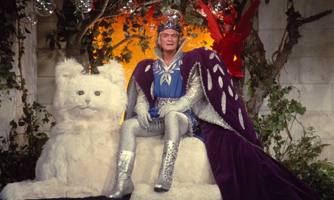 Jean Marais as the Blue King, sitting on his throne.